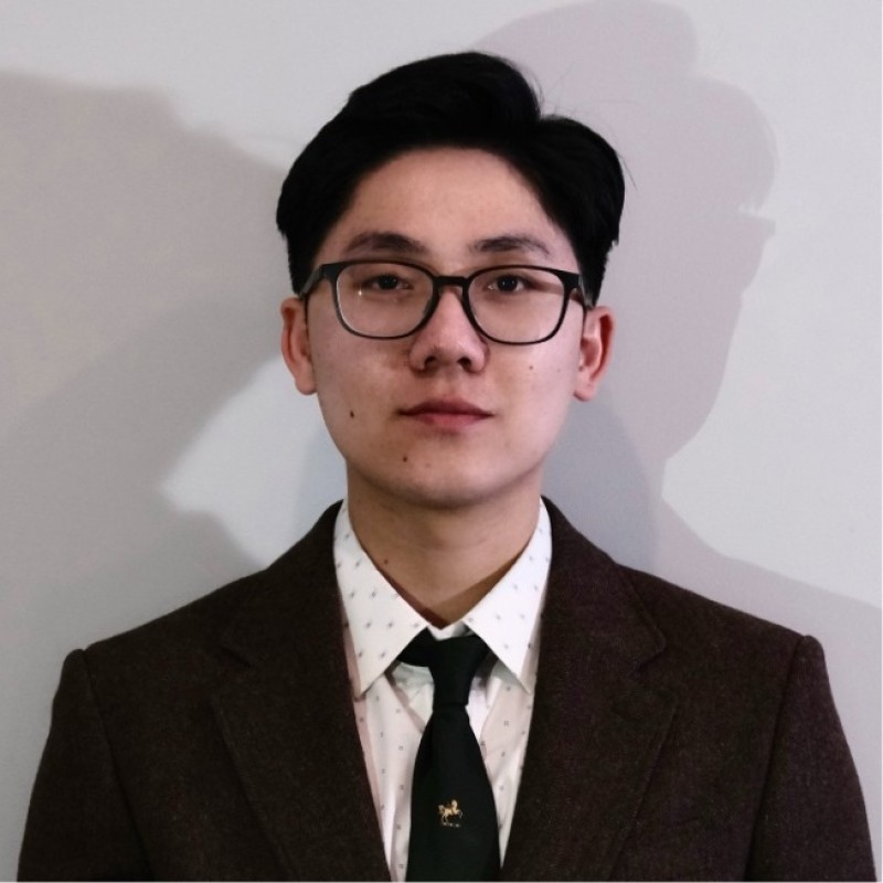 Hugh Vu wearing a suit and glasses
